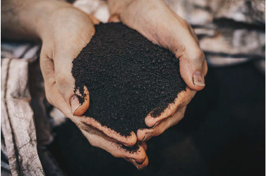 Nahaufnahme von Händen, die RETENTIS®-Wasserspeichergel von Agrobiogel aus einem großen Sack schöpfen.