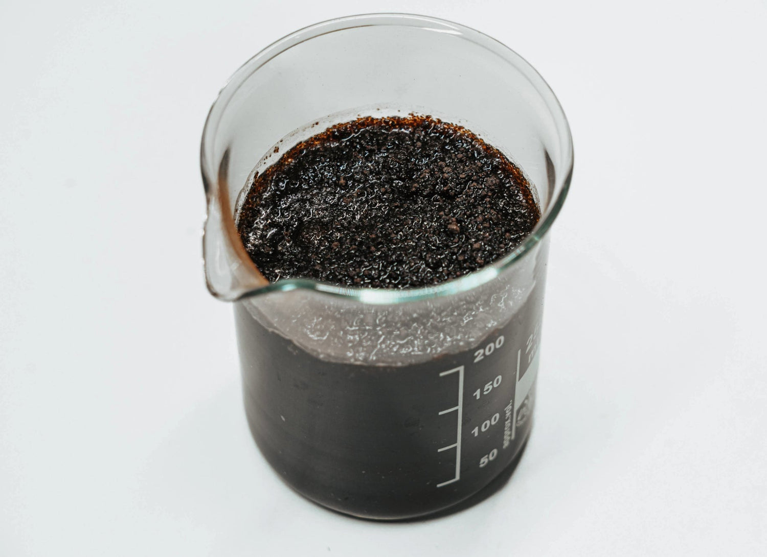 Laborbecher mit gequollenem RETENTIS®-Wasserspeichergel von Agrobiogel, das in Wasser stark aufgegangen ist und die Flüssigkeit gespeichert hat.