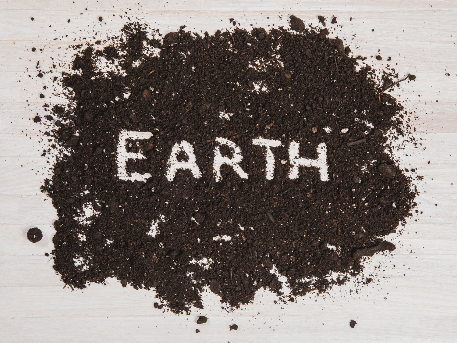 Erde auf einem weißen Tisch wo Earth geschrieben ist