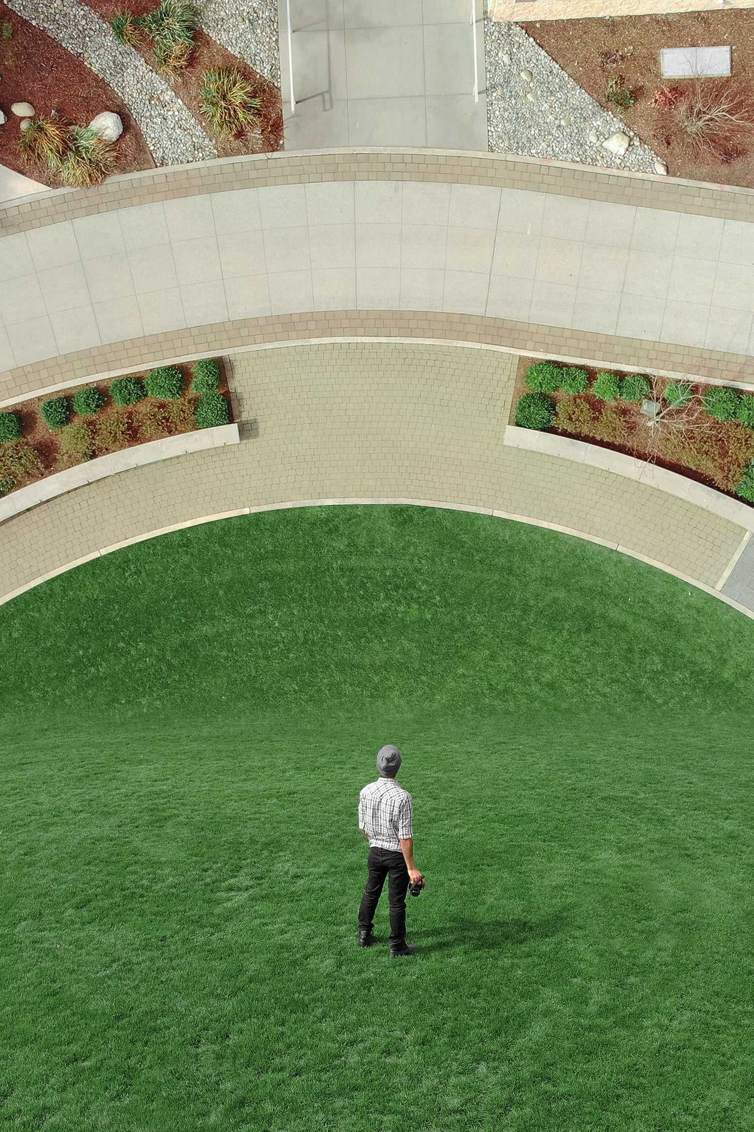 Ein Mann steht in einem Garten mit vertikaler Landschaft die verzerrt ist