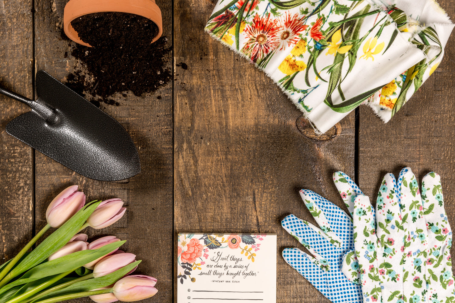 Auf einem Tisch liegen Gartengeräte, Handschuhe eine To Do List und Tulpen